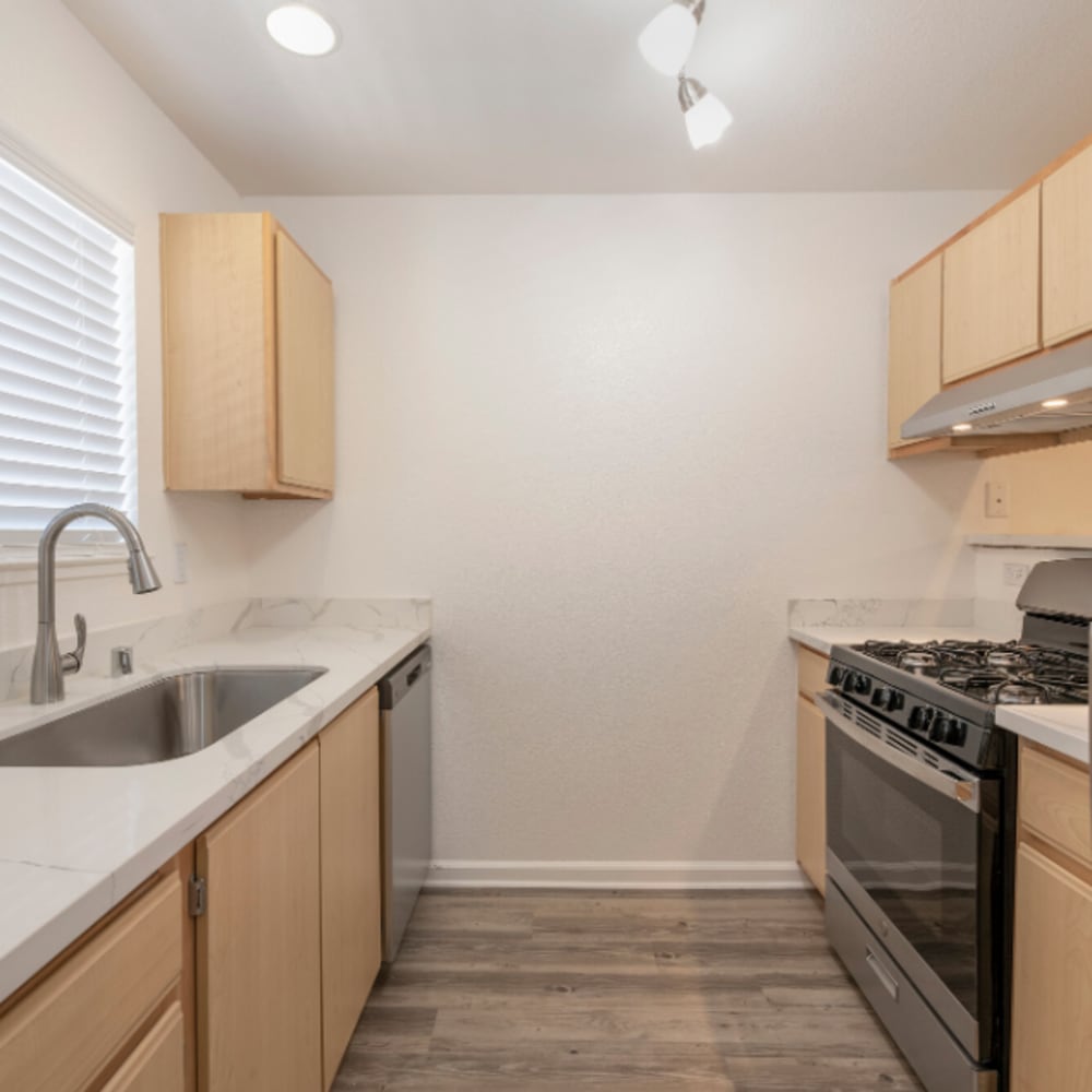 Apartment kitchen with wooden cabinetry at Ava Apartments in Rocklin, California