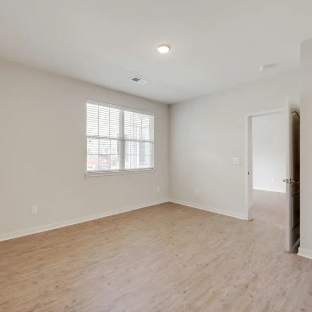 Living room with wood-style flooring at Creekside At Deer Crossings in White House, Tennessee