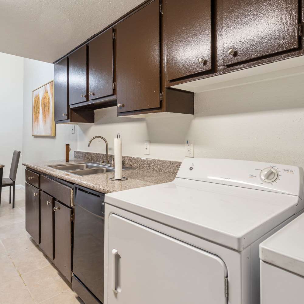 Washer and dryer beside a sink at Huntington Village And Cambridge Crossing in Houston, Texas