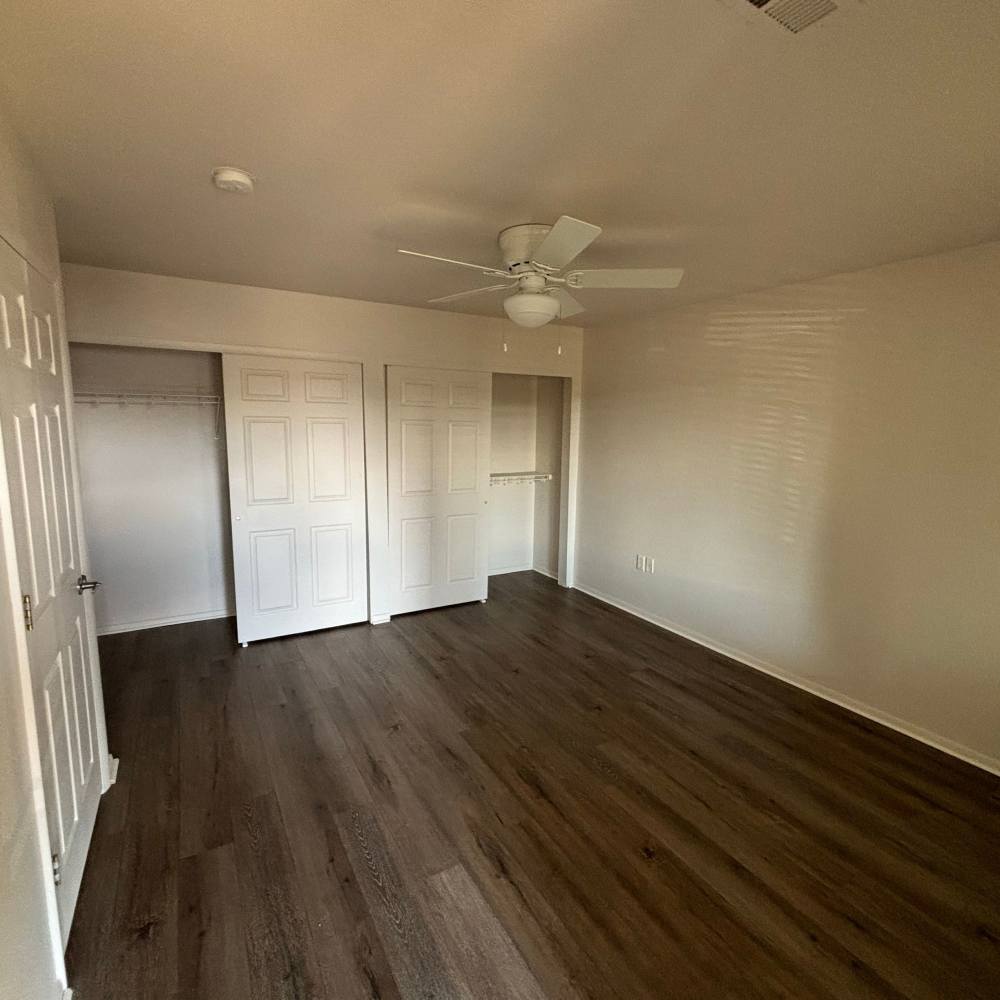 Spacious living room with wood-style flooring at Castlebar Apartments in Bozeman, Montana