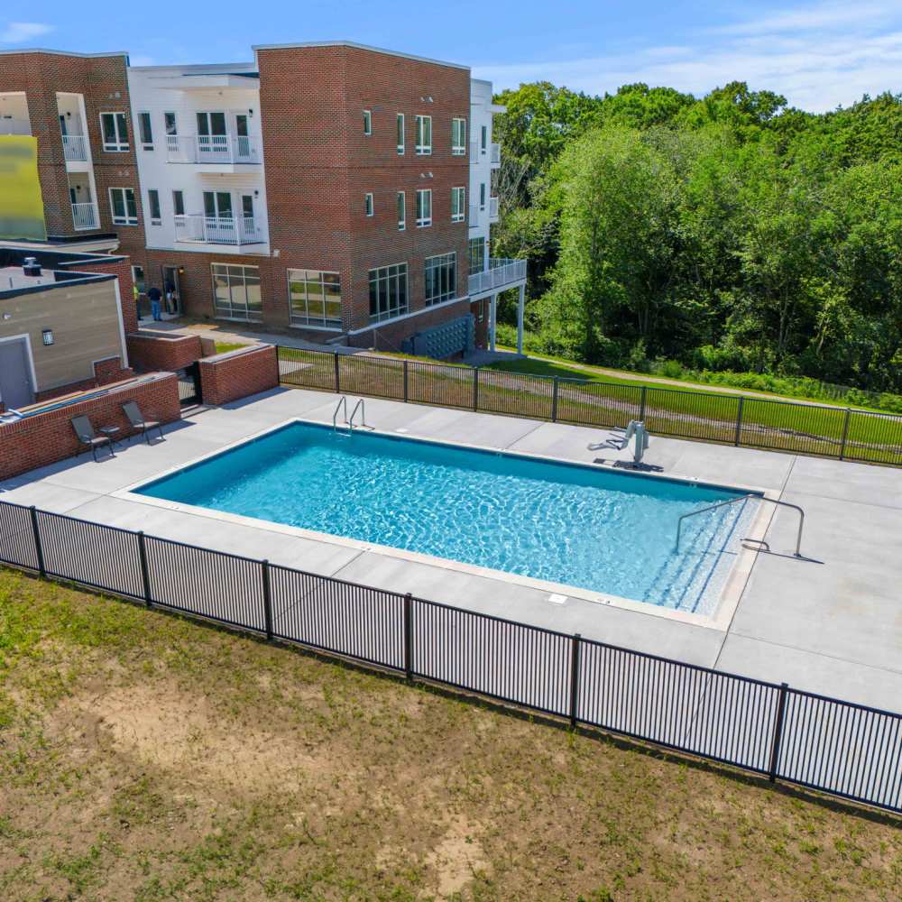 A serene backyard pool surrounded by a protective fence, located in 60 Mansfield Road, New London, Connecticut.