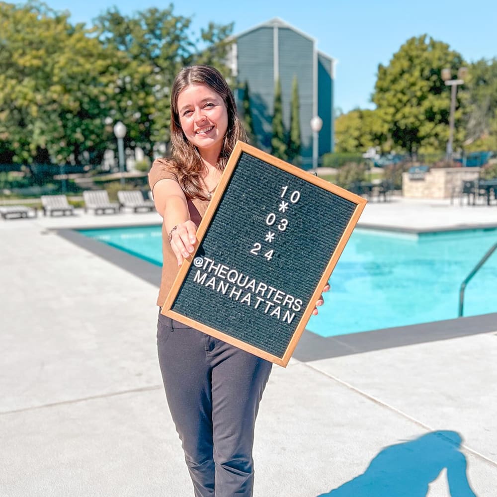 Resident holding a sign at The Quarters Manhattan in Manhattan, Kansas