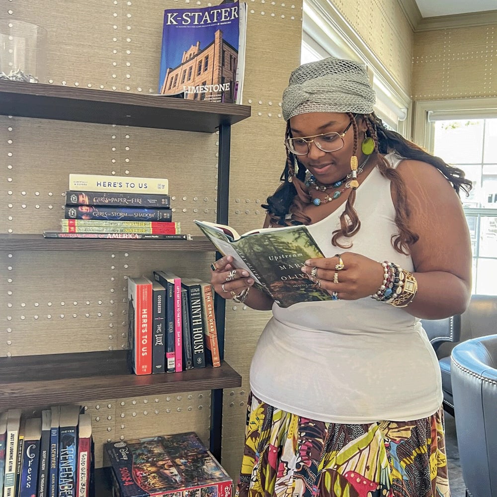 Student reading a book at The Quarters Manhattan in Manhattan, Kansas