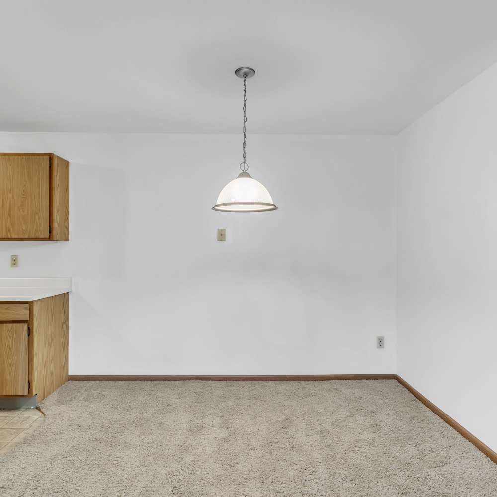 Empty kitchen room with plush carpet flooring at Prairie Apartments in Salem,Wisconsin