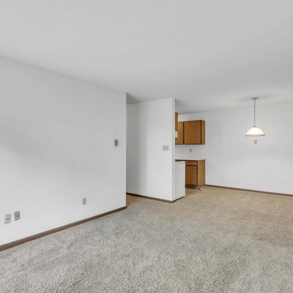 Empty aparment living room with kitchen in the background at Prairie Apartments in Salem,Wisconsin
