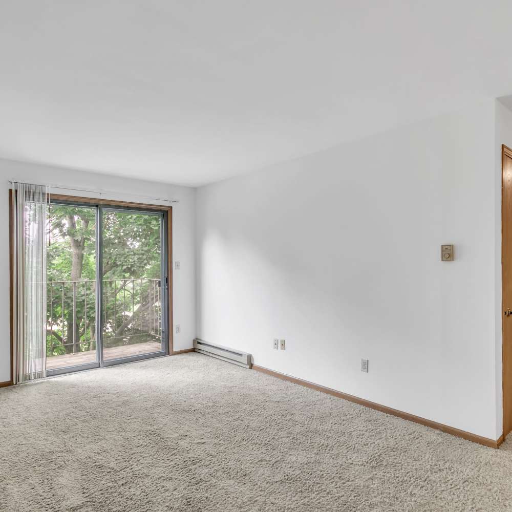 Apartment living room with carpet flooring and balcony access at Prairie Apartments in Salem,Wisconsin