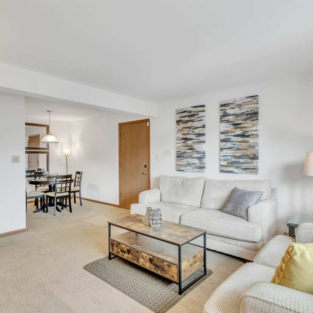 Spacious living room with beautiful wall art and dining area in the background at Prairie Apartments in Salem,Wisconsin
