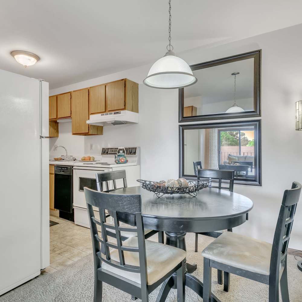 Four seater dining setup and kitchen in the background at Prairie Apartments in Salem,Wisconsin