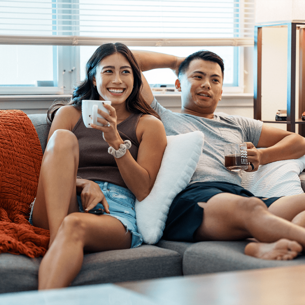 Couple sitting on their couch at Solero at Plantation in Plantation, Florida /apartments/fl/plantation/33/  