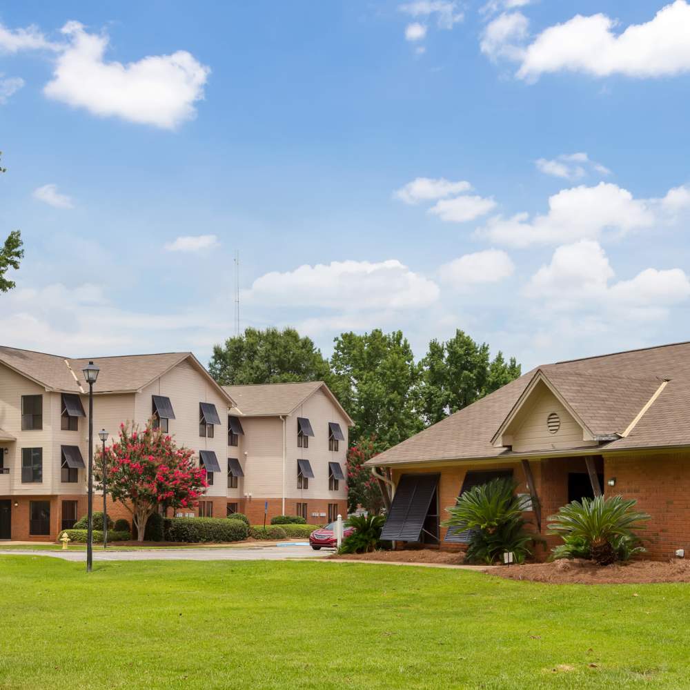 Open lawn and a view of the apartment buildings at The Arbors On Taylor in Montgomery, Alabama
