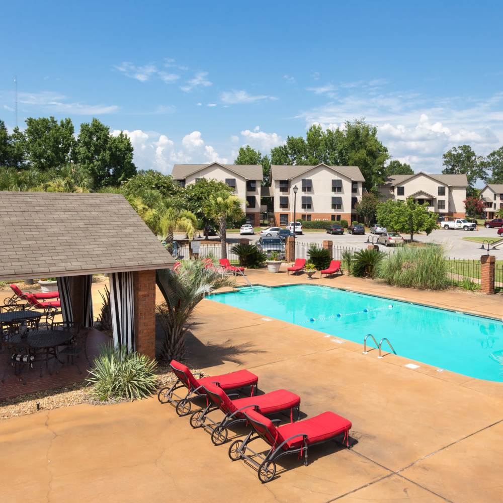 Resort-style swimming pool with lounge chairs and cabana at The Arbors On Taylor in Montgomery, Alabama