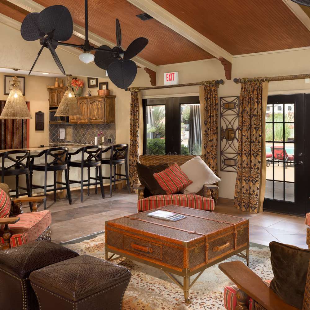 Clubhouse with multiple seating, coffee table and a kitchen with a counter and chairs at The Arbors On Taylor in Montgomery, Alabama