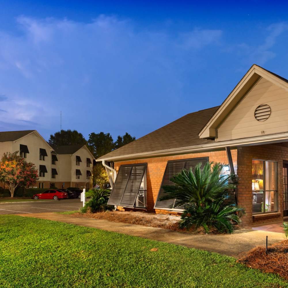 view of the apartment building surrounded by greenery at The Arbors On Taylor in Montgomery, Alabama