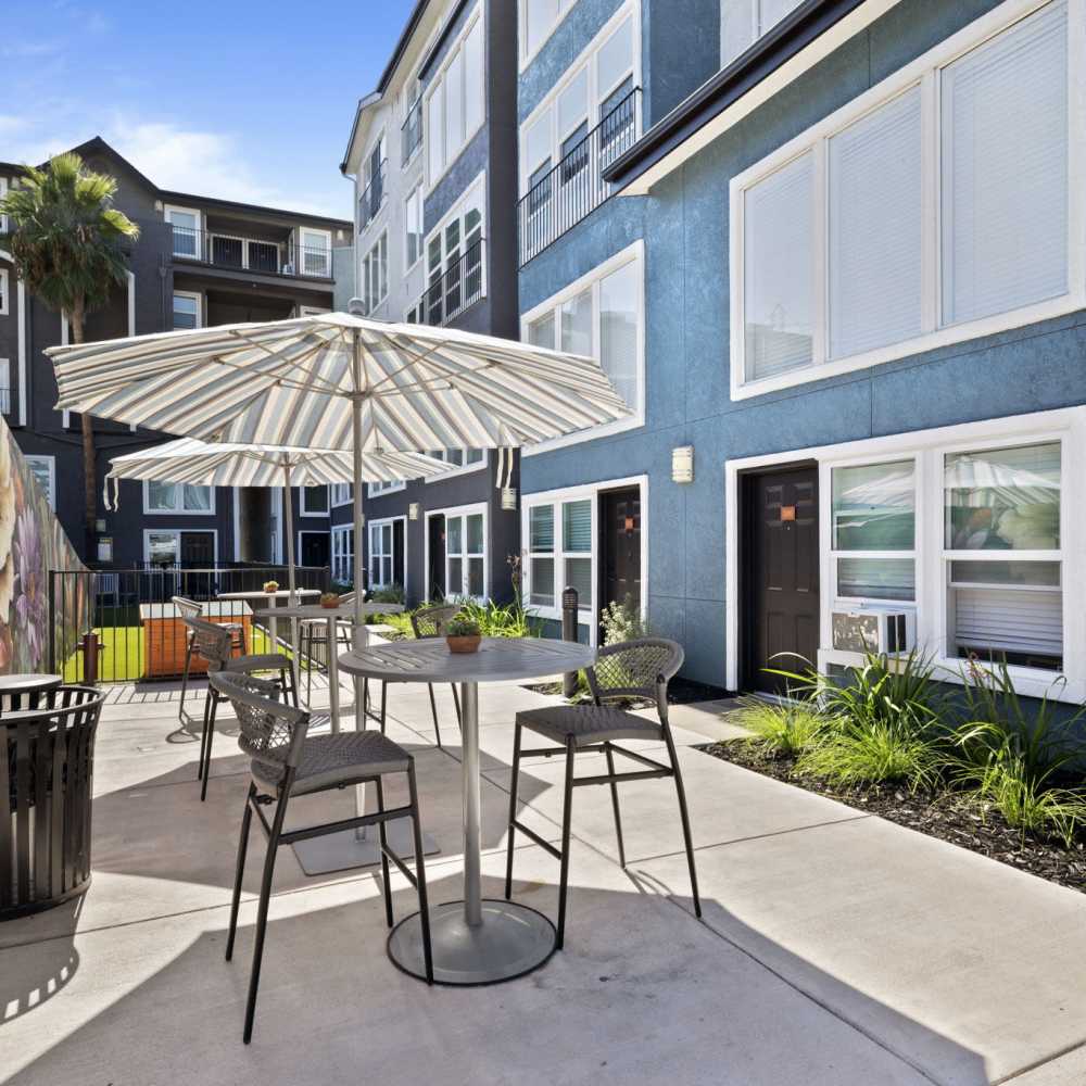 Exterior seating area with umbrellas at One55 Lofts in San Rafael, California