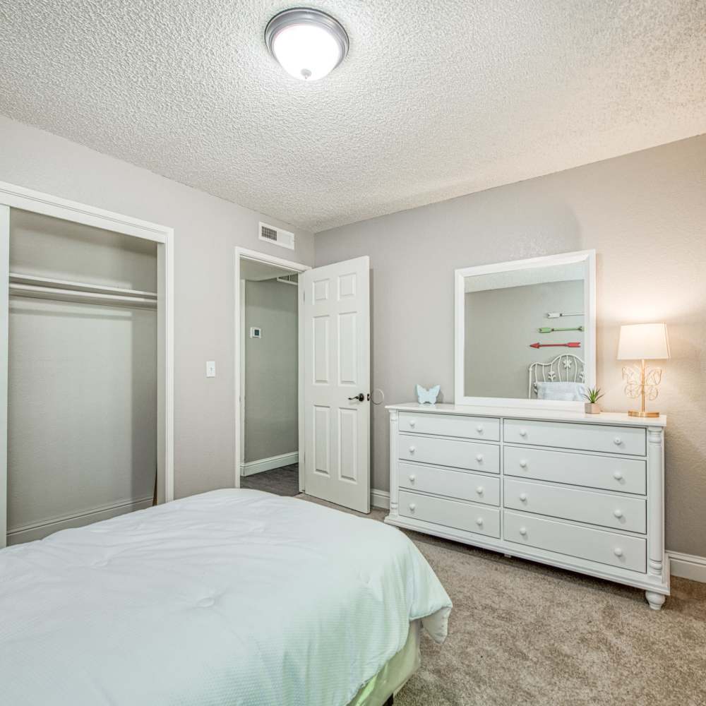 Spacious bedroom with connecting bathroom, plush carpeting, and lots of storage space at The Landing at Fancher Creek in Fresno, California, 