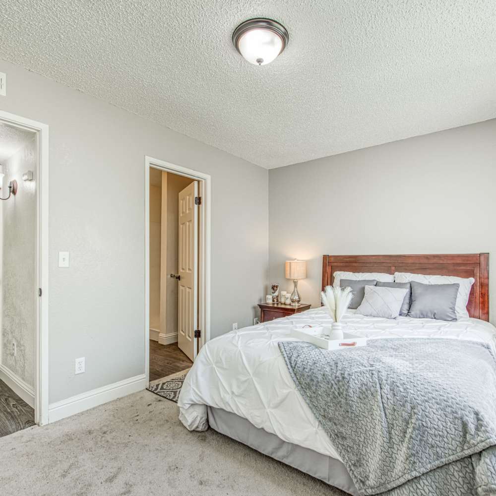 Well-lit bedroom with plush carpeting at The Landing at Fancher Creek in Fresno, California, 