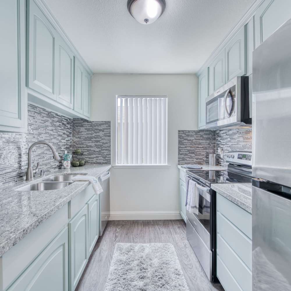 Stainless steel stove, drawer microwave, and sink with granite countertops at The Landing at Fancher Creek in Fresno, California, 