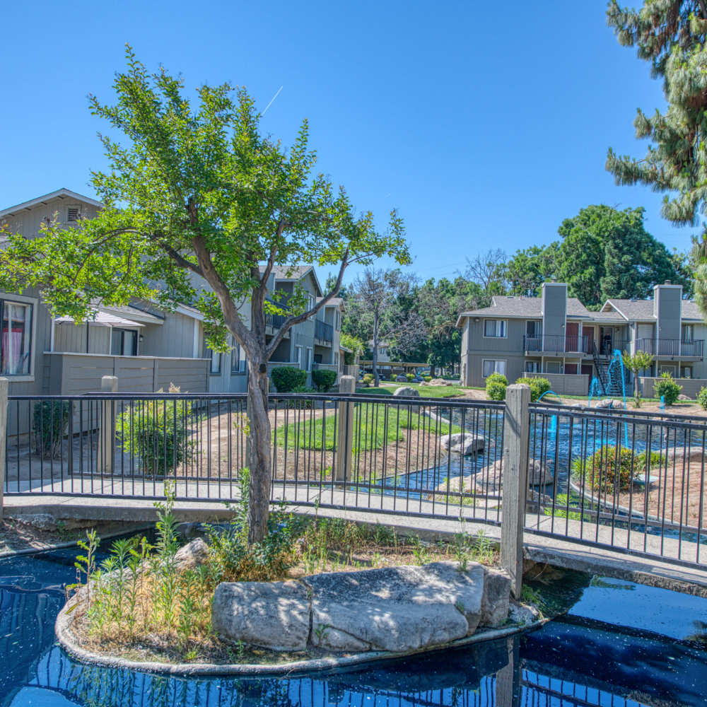 Beautiful view of lake, surrounding green grass and trees right outside apartments at The Landing at Fancher Creek in Fresno, California, 
