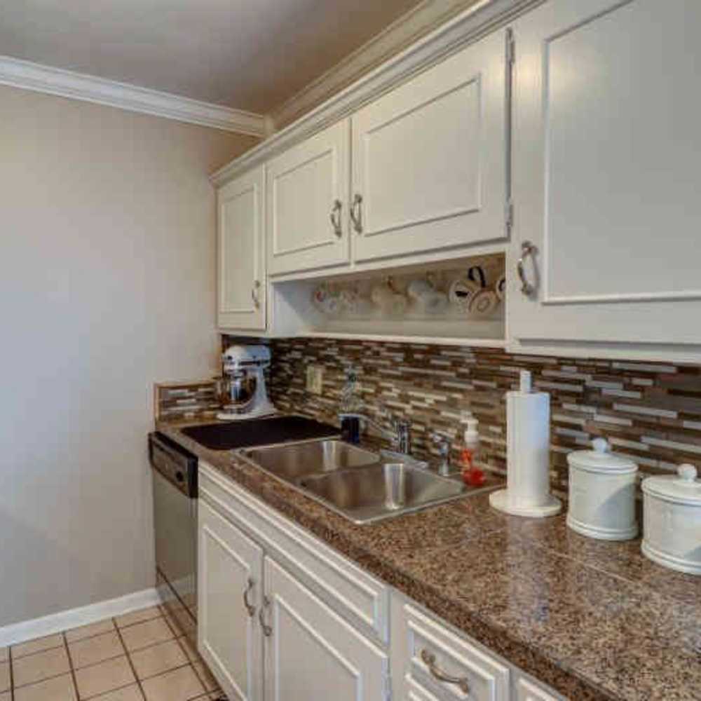 Modern kitchen with wooden cabinets, microwave and a refrigerator at Woodmont Terrace in Nashville, Tennessee