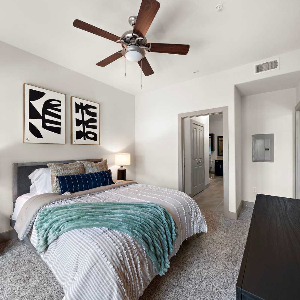 Carpeted bedroom with full size bed and ceiling fan at 3800 Main in Houston, Texas