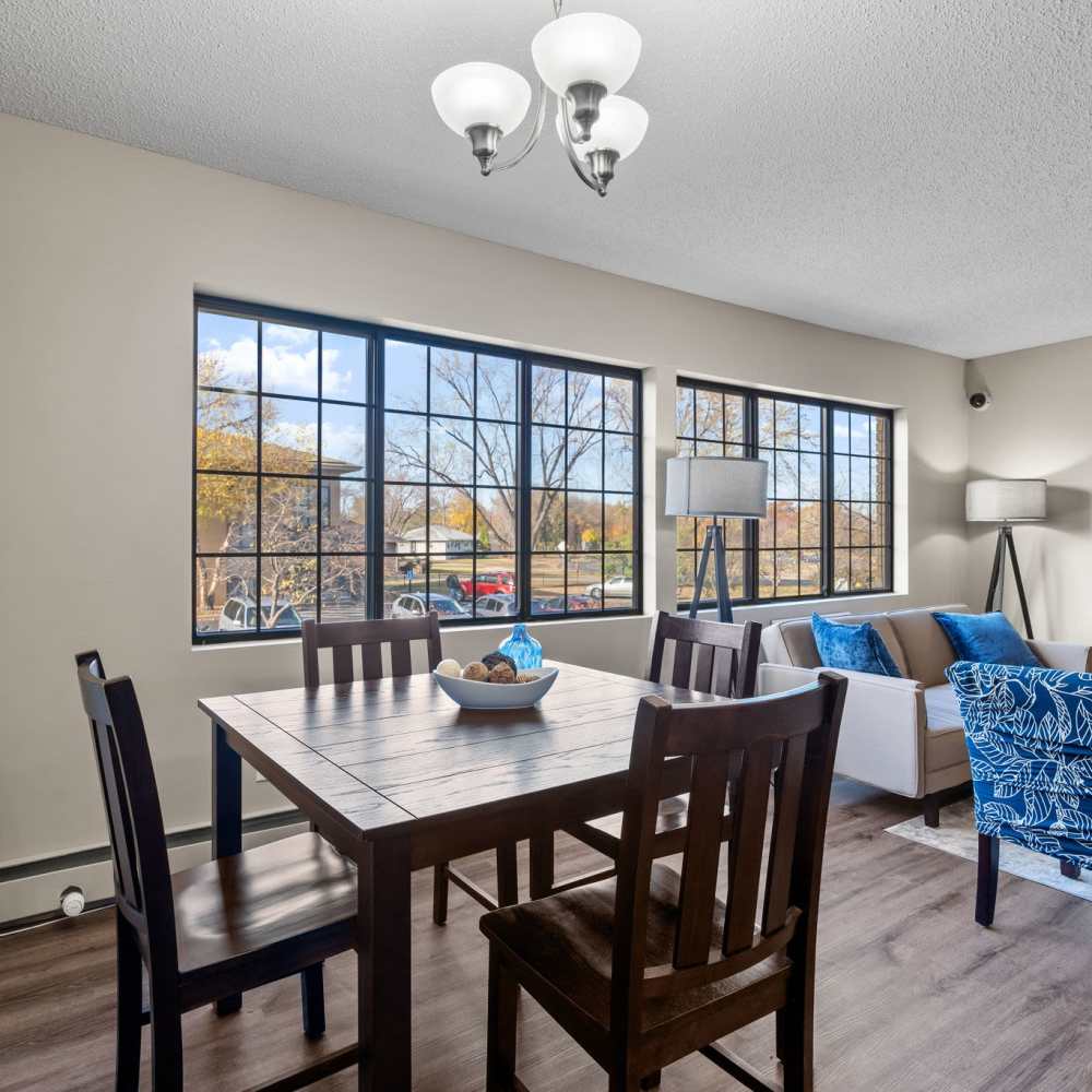 Dining area with a table and chairs and large windows at Granite Peaks in Minneapolis, Minnesota