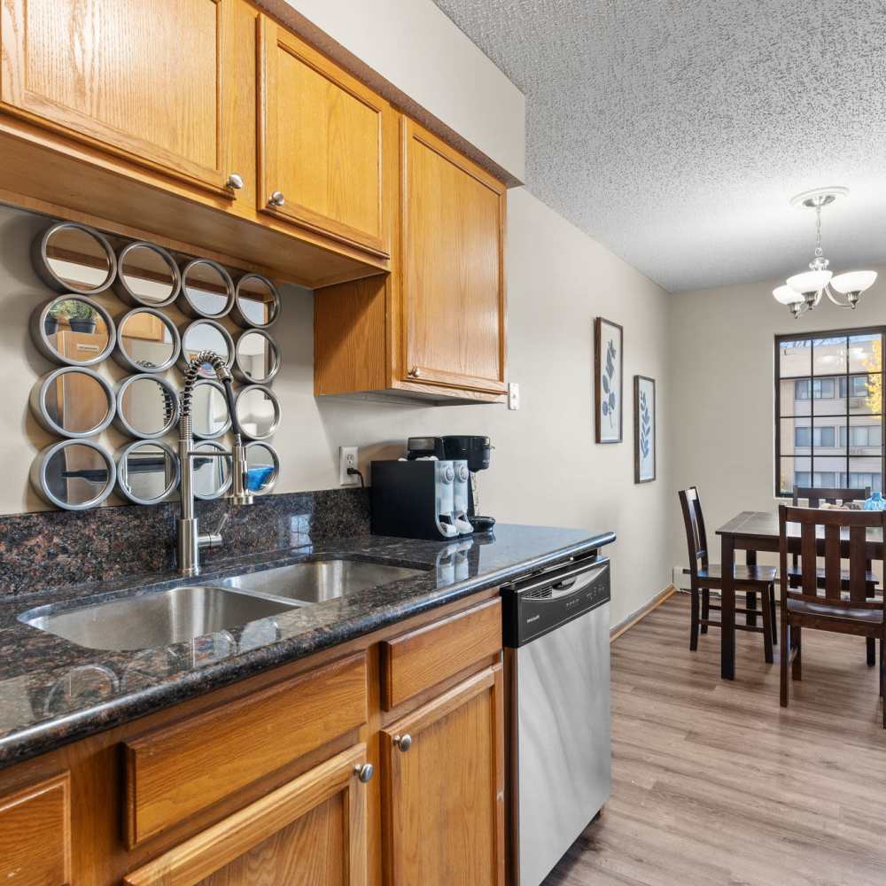 Kitchen with wooden cabinets, granite countertops at Granite Peaks in Minneapolis, Minnesota