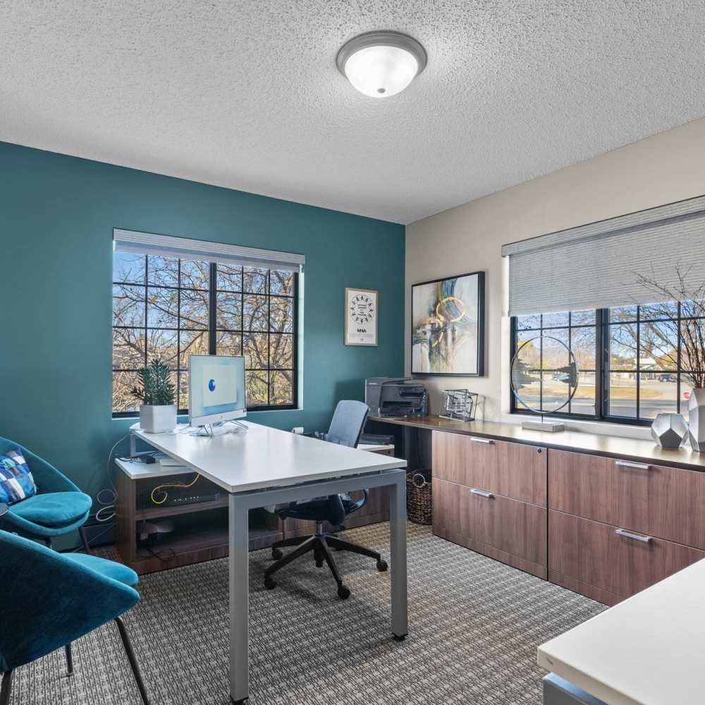 Community office room with a desktop, multiple windows and storage units at Granite Peaks in Minneapolis, Minnesota