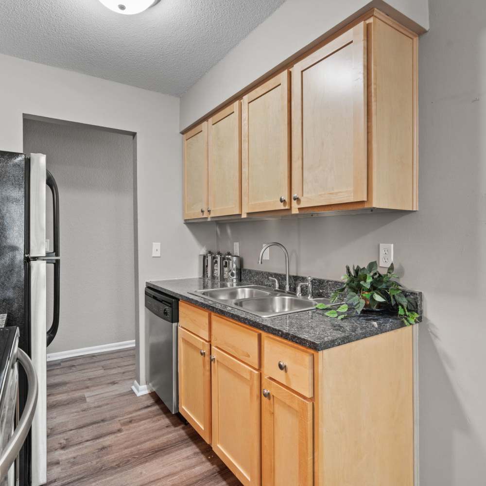 Kitchen with light walnut color cabinet and granite countertop at Granite Ridge in Brooklyn Park, Minnesota