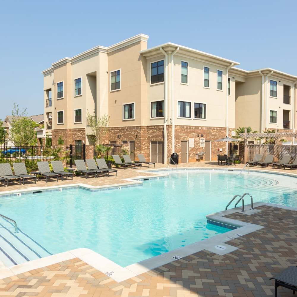 Large swimming pool with multiple sun loungers at Terraces at Suwanee Gateway in Suwanee,Georgia
