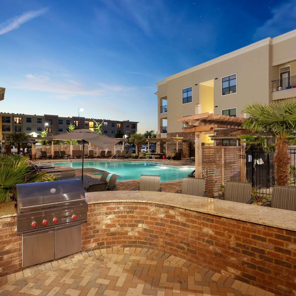 Outdoor BBQ area adjacent to the community pool at Terraces at Suwanee Gateway in Suwanee,Georgia