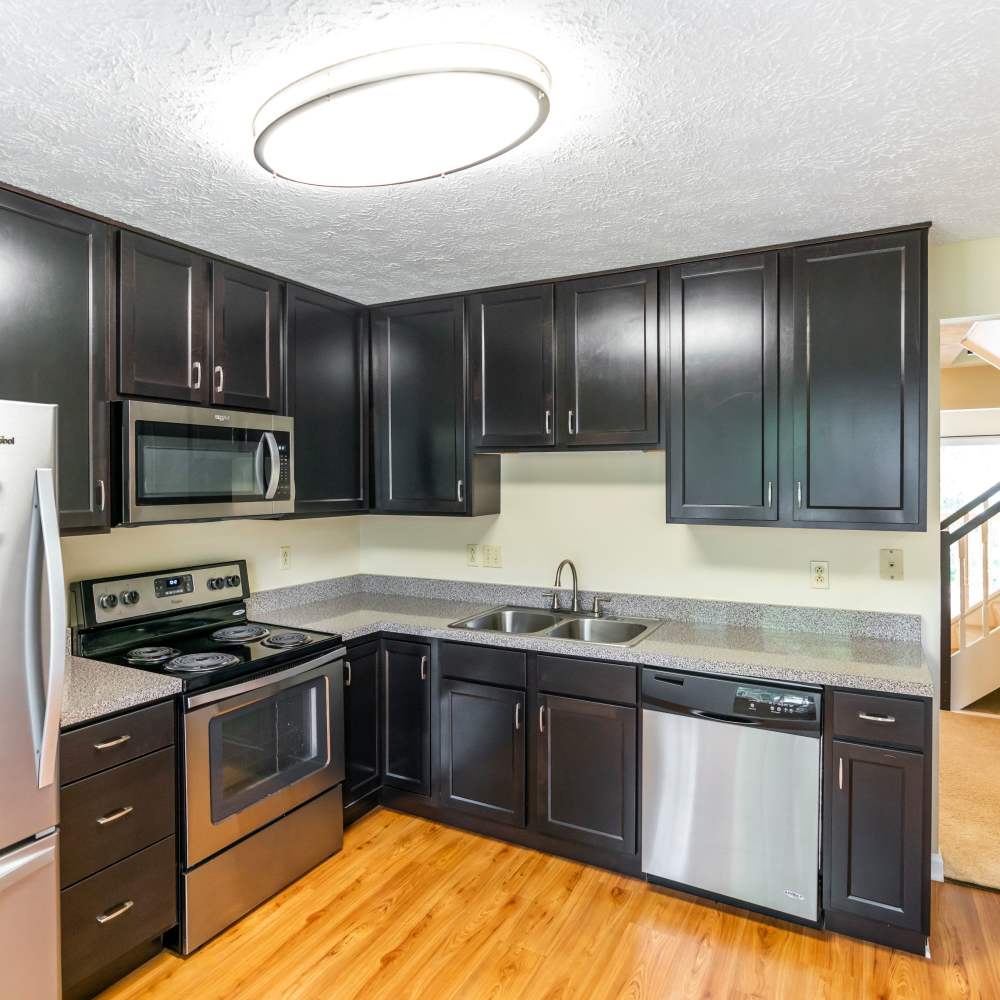 Modern kitchen with wooden cabinets and stainless-steel appliances at Hawthorne Estates, Oakdale, Pennsylvania