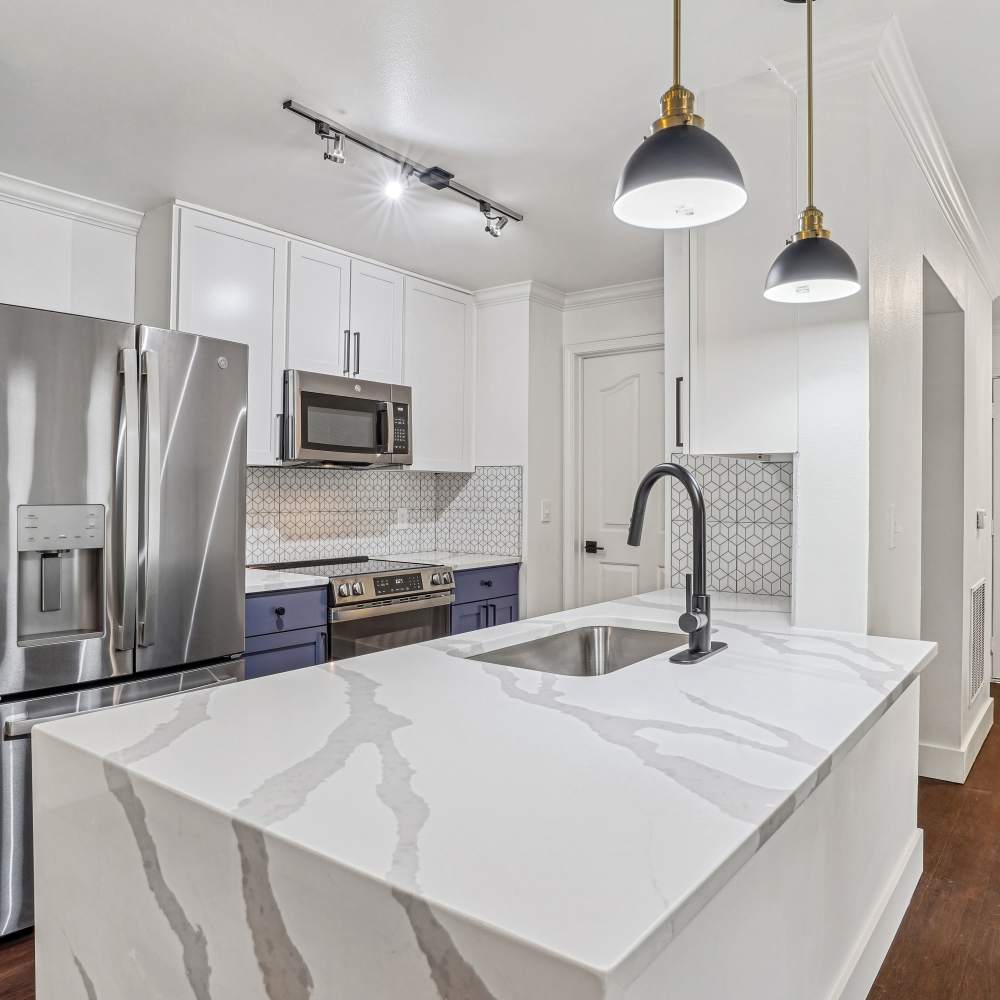 Kitchen with hanging lights and cabinets at Cypress in McKinney, Texas