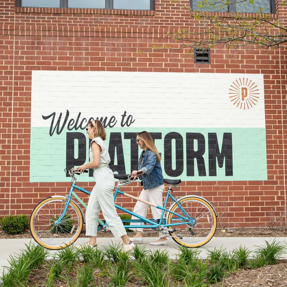 Two women with a tandem bicycle at Kane Residential in Raleigh, North Carolina
