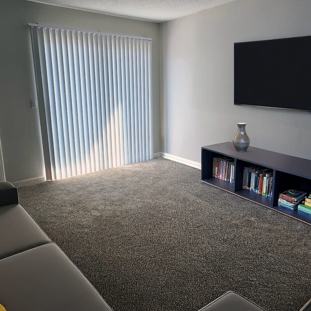 Living room with a door out to a private patio at Dominion House Apartments in Nashville, Tennessee