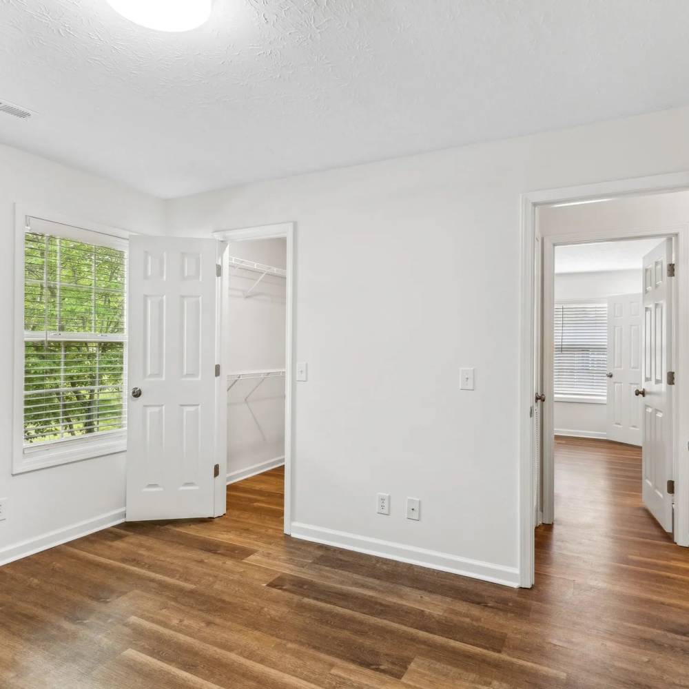 Bright windows in a home with wood-style flooring at The Bellevue At 1045 in Cookeville, Tennessee