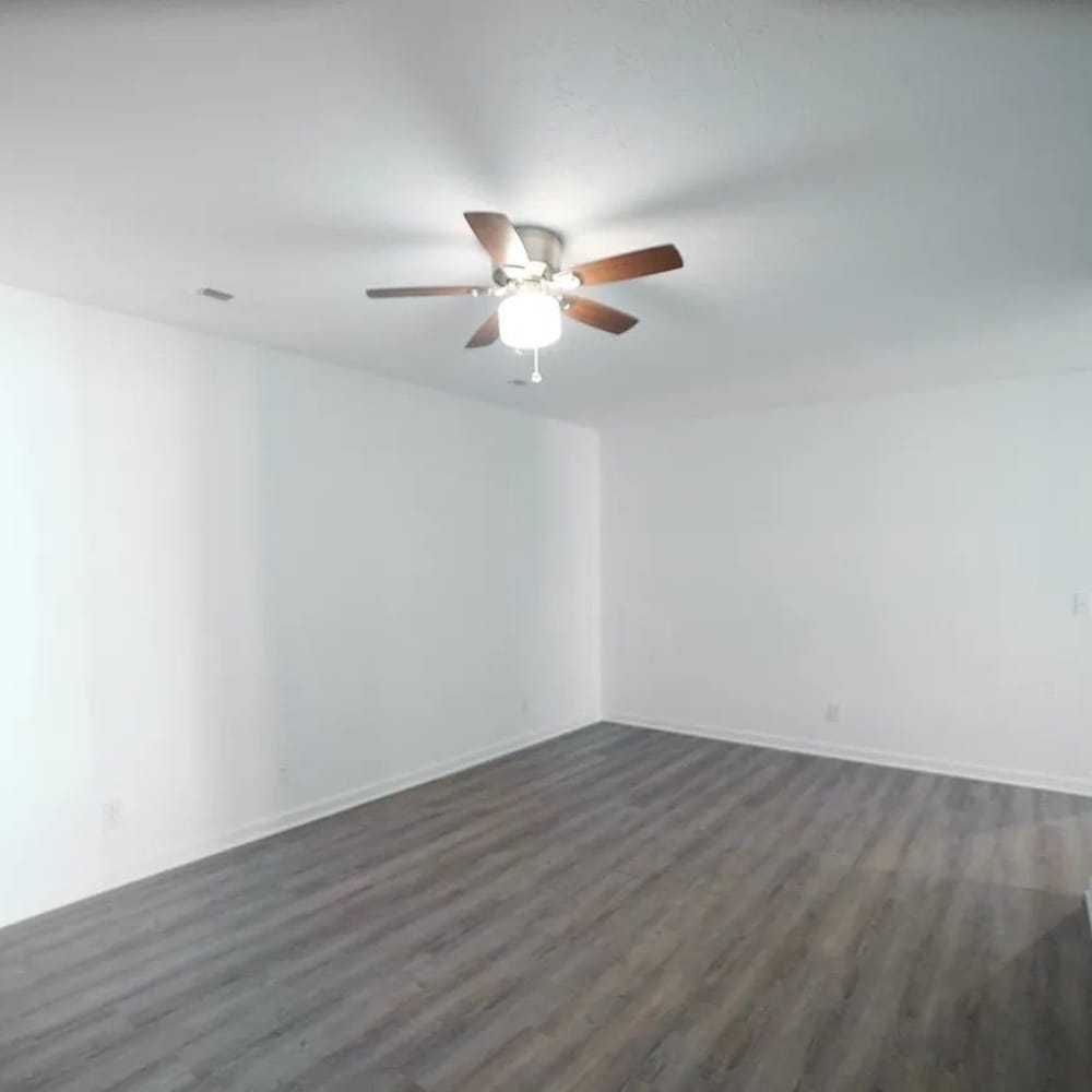 Spacious living area with wood-style flooring at The Bellevue At 1045 in Cookeville, Tennessee