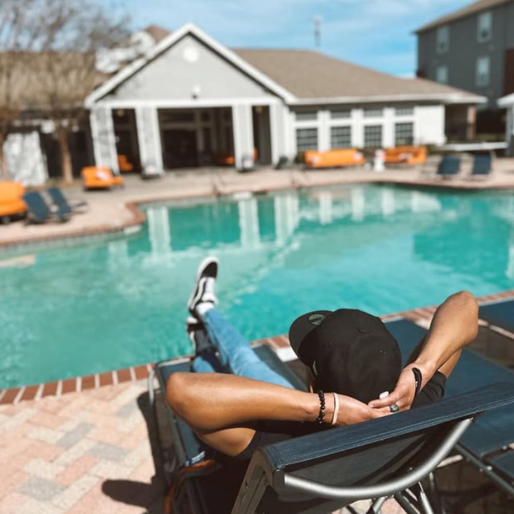 Resident lounging around the swimming pool at The Beacon Auburn in Auburn, Alabama