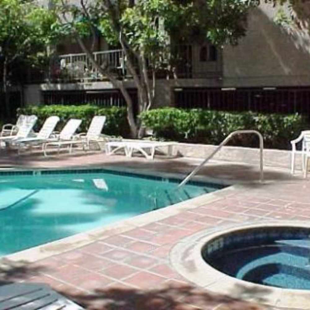 Sparkling swimming pool with lounge chairs at Encino Crest Apartments in Encino, California