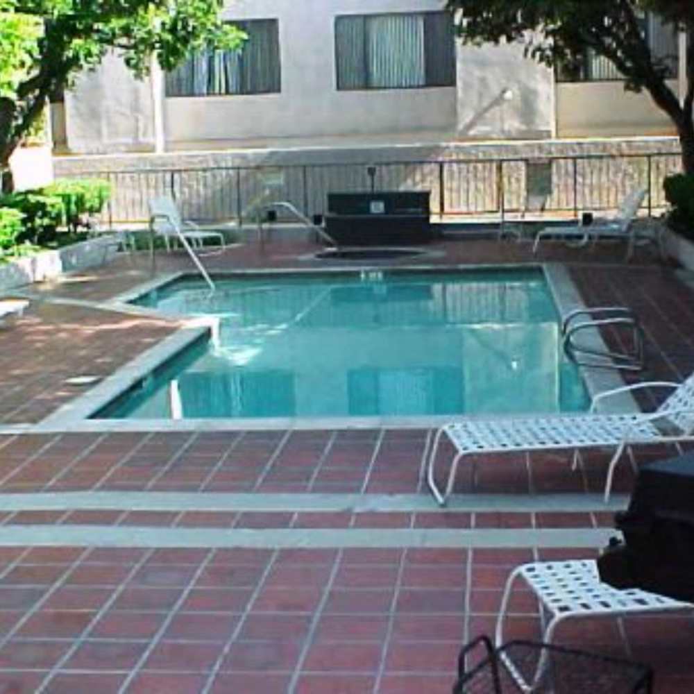 Pool with lounge chairs at Encino Crest Apartments in Encino, California