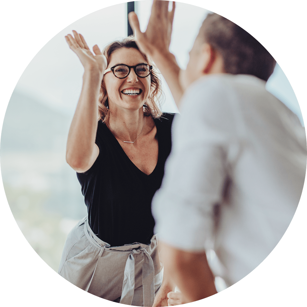 Woman and man high-fiving at Drucker + Falk in Newport News, Virginia