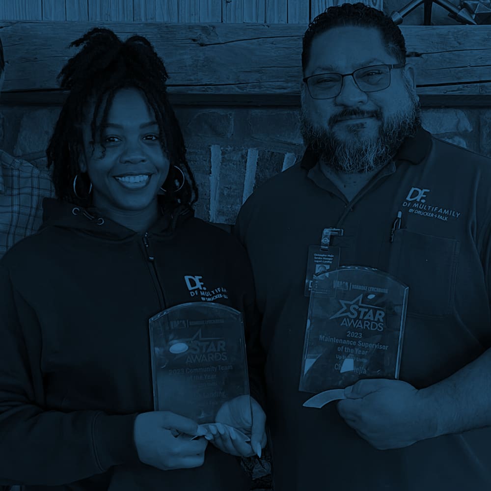 Two employees holding awards at Drucker + Falk in Newport News, Virginia