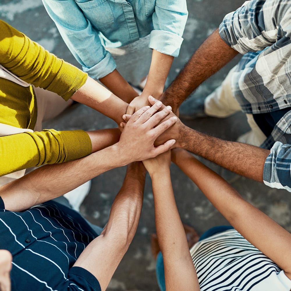 Group of team members with their hands stacked at Drucker + Falk in Newport News, Virginia