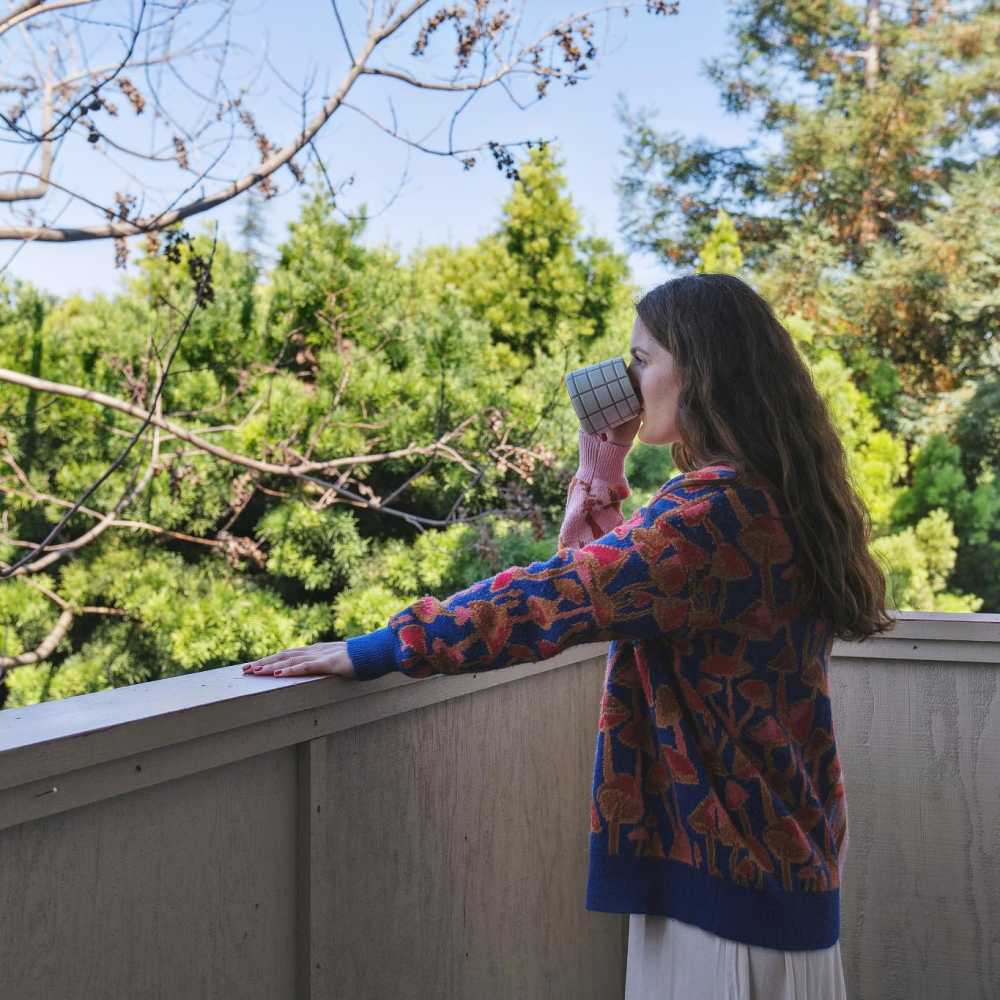 a woman standing on the terrace drinking a cup of coffee at Del Coronado in Alameda, California