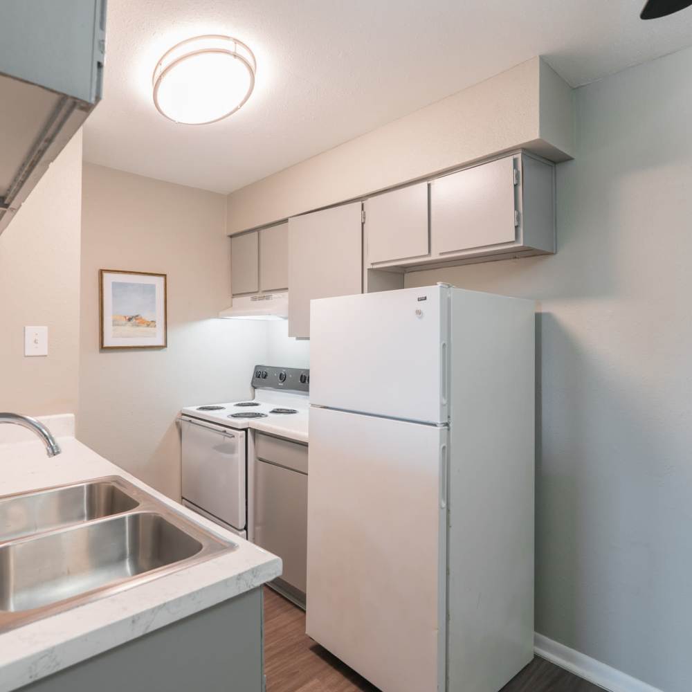  Modern kitchen with wooden cabinets, granite countertops and stainless-steel appliances at The Grand 1501 in College Station, Texas