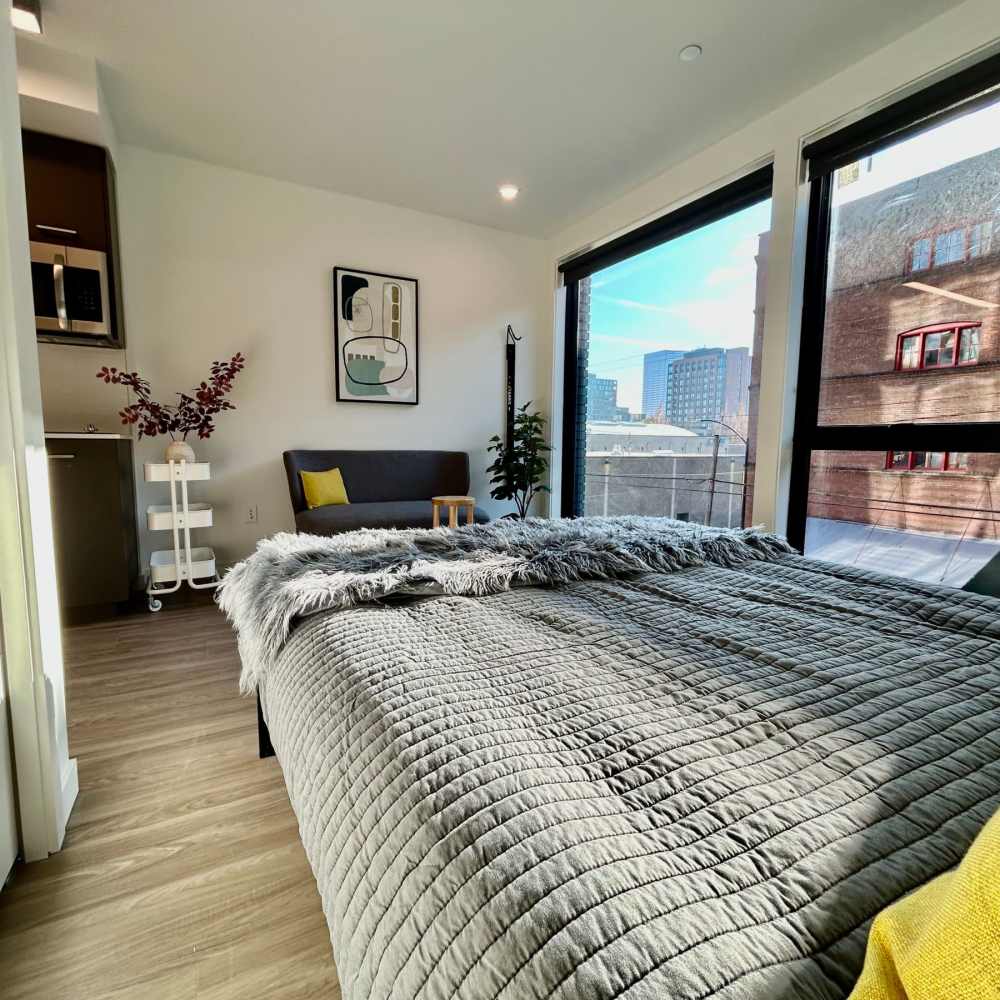 Bed in an apartment with large windows at DOCK 59 in Portland, Oregon