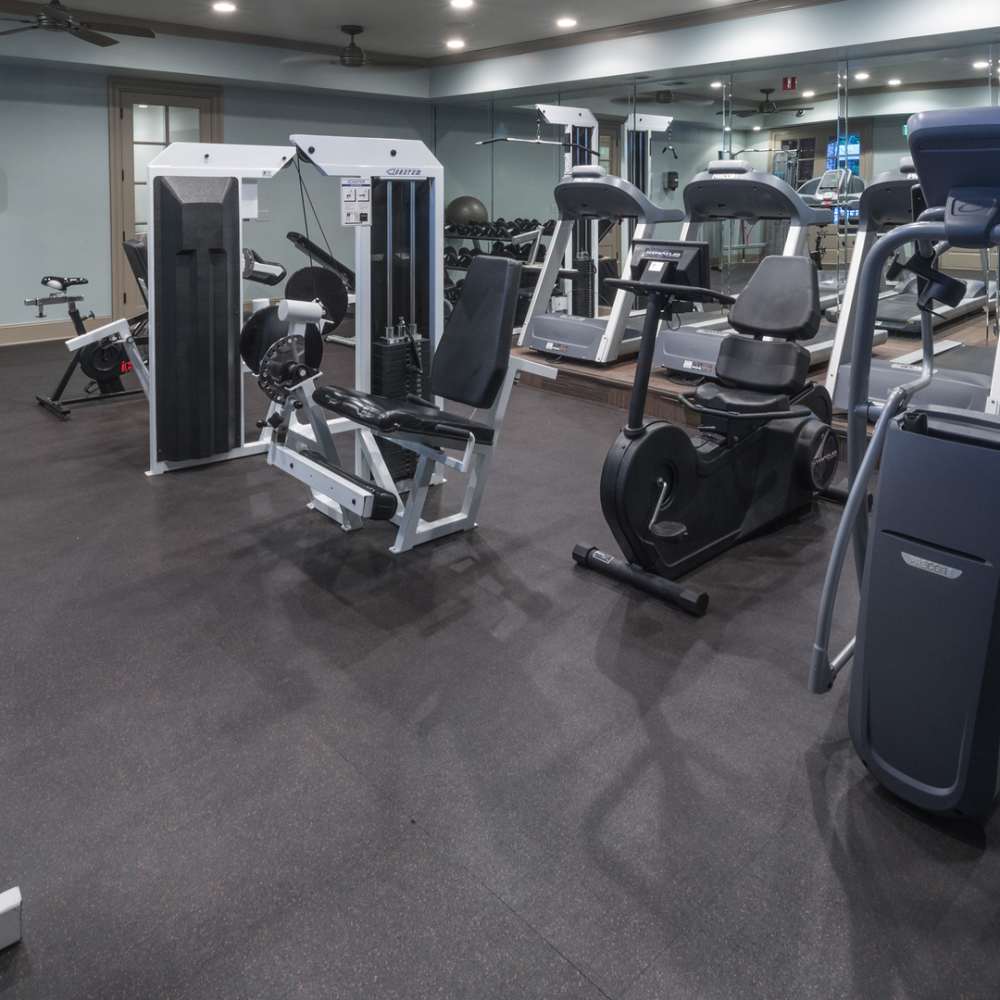 Well-equipped fitness center with treadmills and weight-lifting machines at Avonlea On The River in Duluth, Georgia
