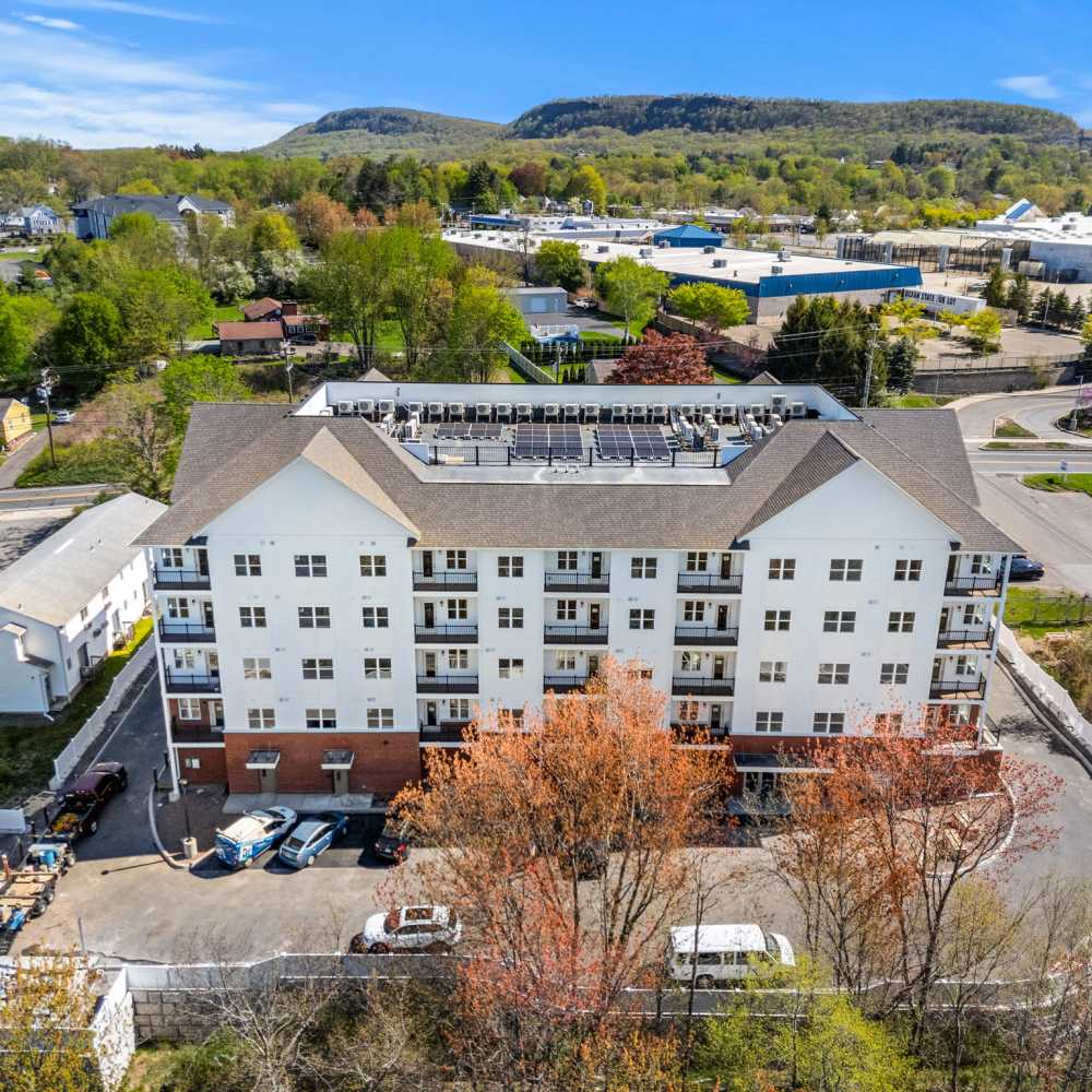 Exterior photo with trees and cars at Pomeroy Apartments in Meriden, Connecticut