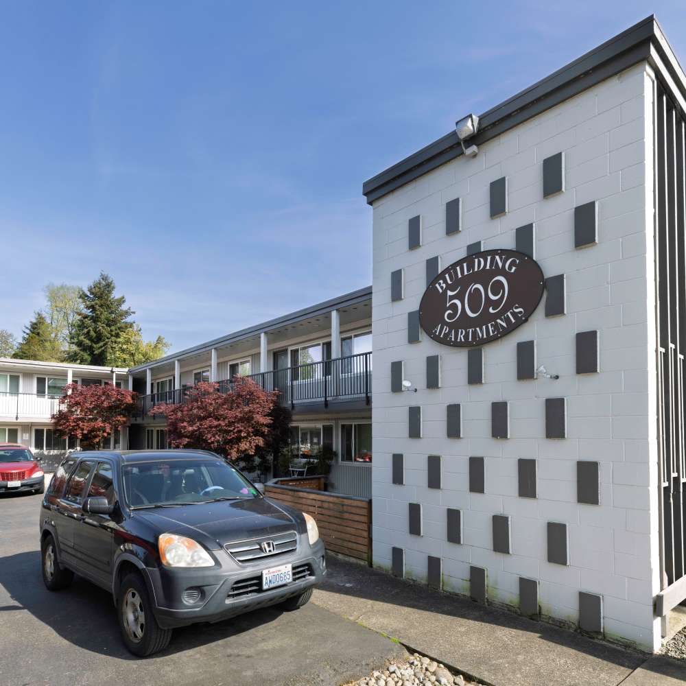View of car and apartment exterior at Brentwood 509 Apartments in Olympia, Washington