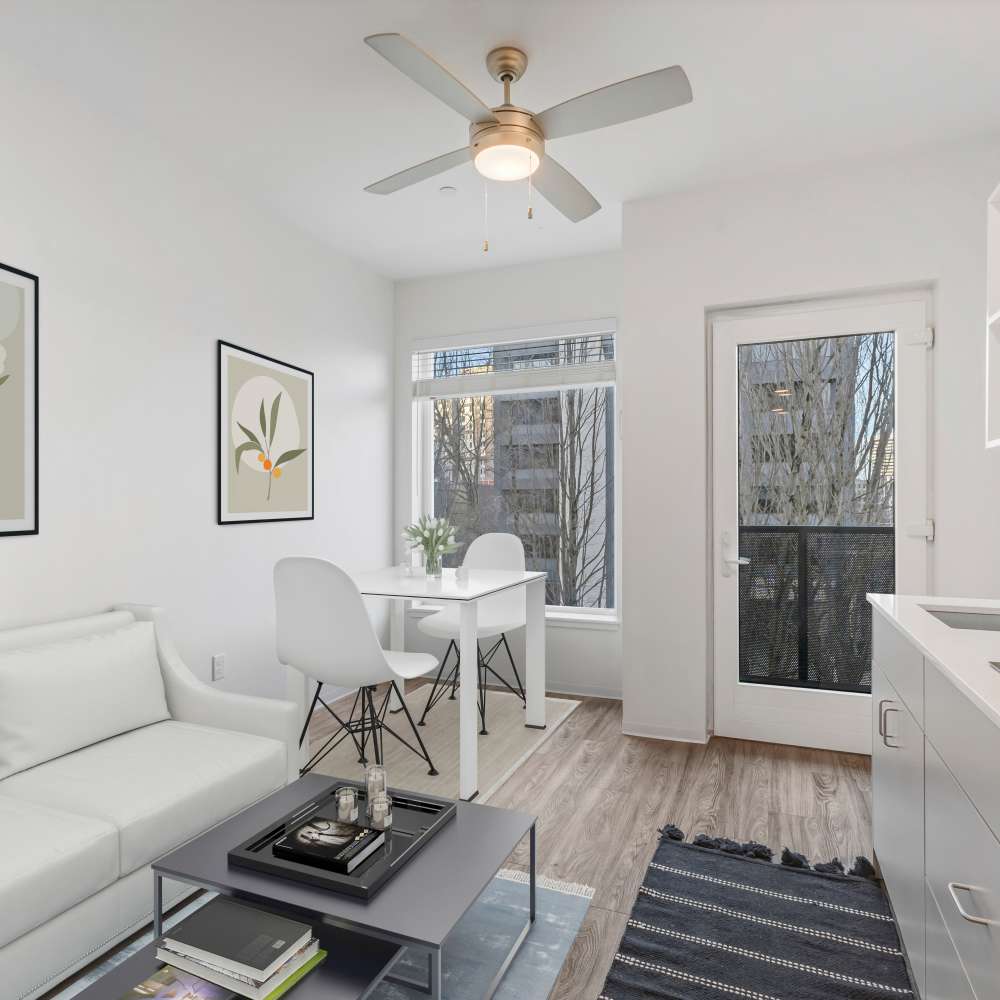 Modern, bright apartment interior with white walls, ceiling fan, and minimalist furniture at Koz on 4th in Portland, Oregon