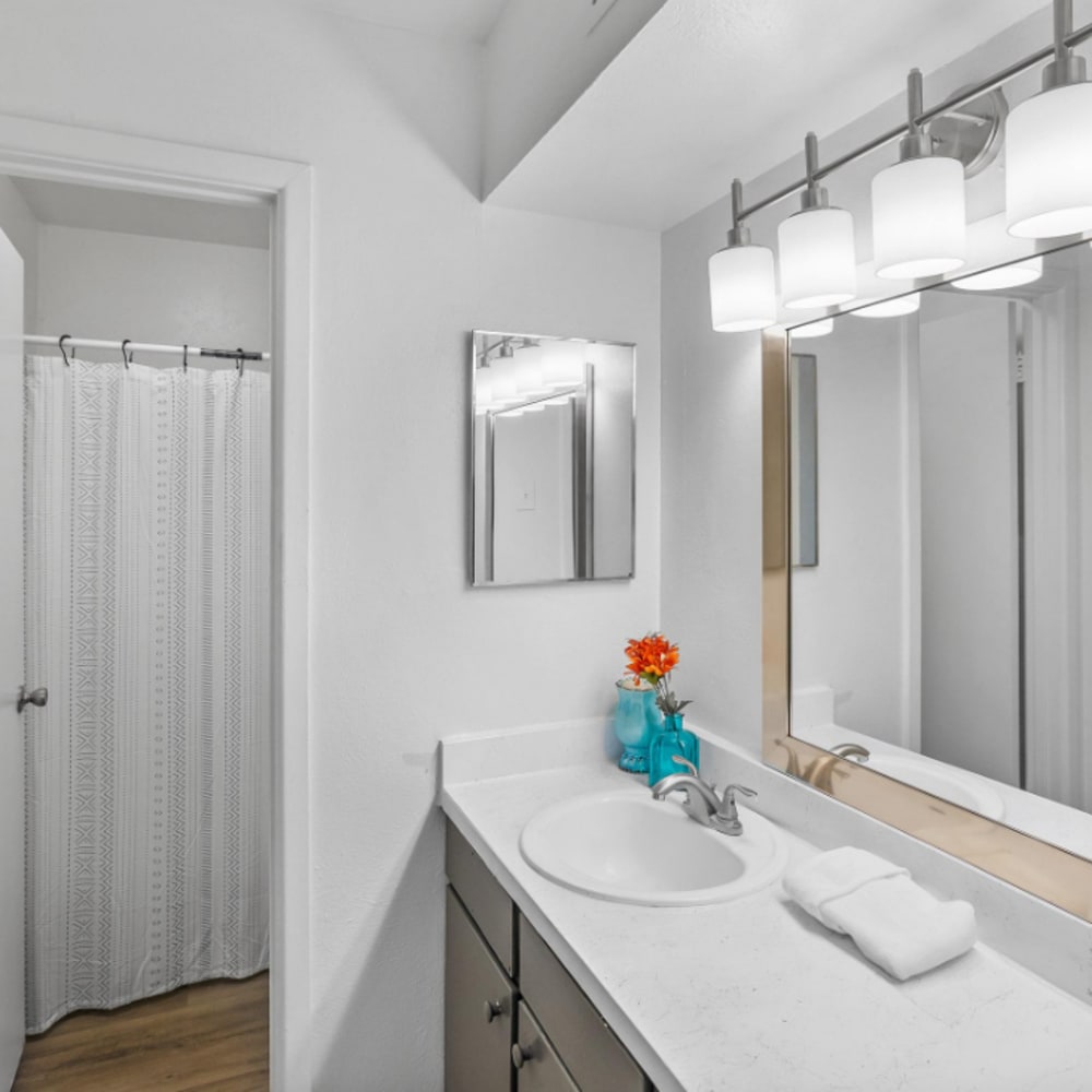 Apartment bathroom with a mirror and white vanity unit at The Hayes Apartments in Fort Worth,Texas